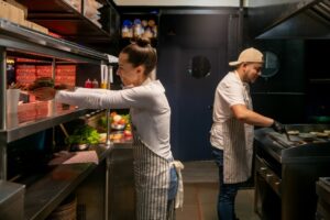 pracownicy w kuchni restaurtacyjnej